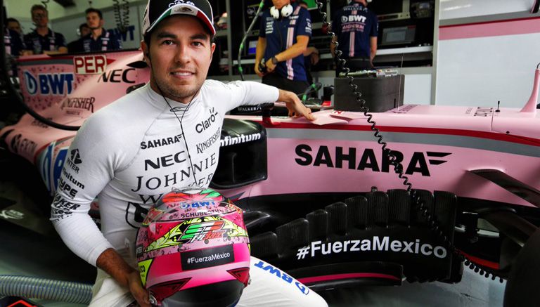 Checo luce su casco junto a su monoplaza de Force India