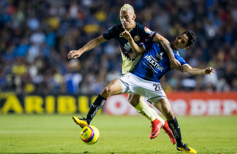 Mateus Uribe disputa el balón contra Jaime Gómez del Querétaro