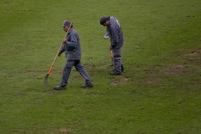 Trabajadores del Estadio Azteca revisan el terreno de juego