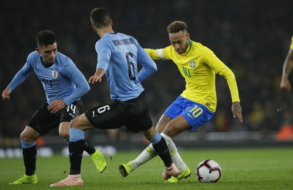 Neymar conduce el esférico entre varios rivales de Uruguay