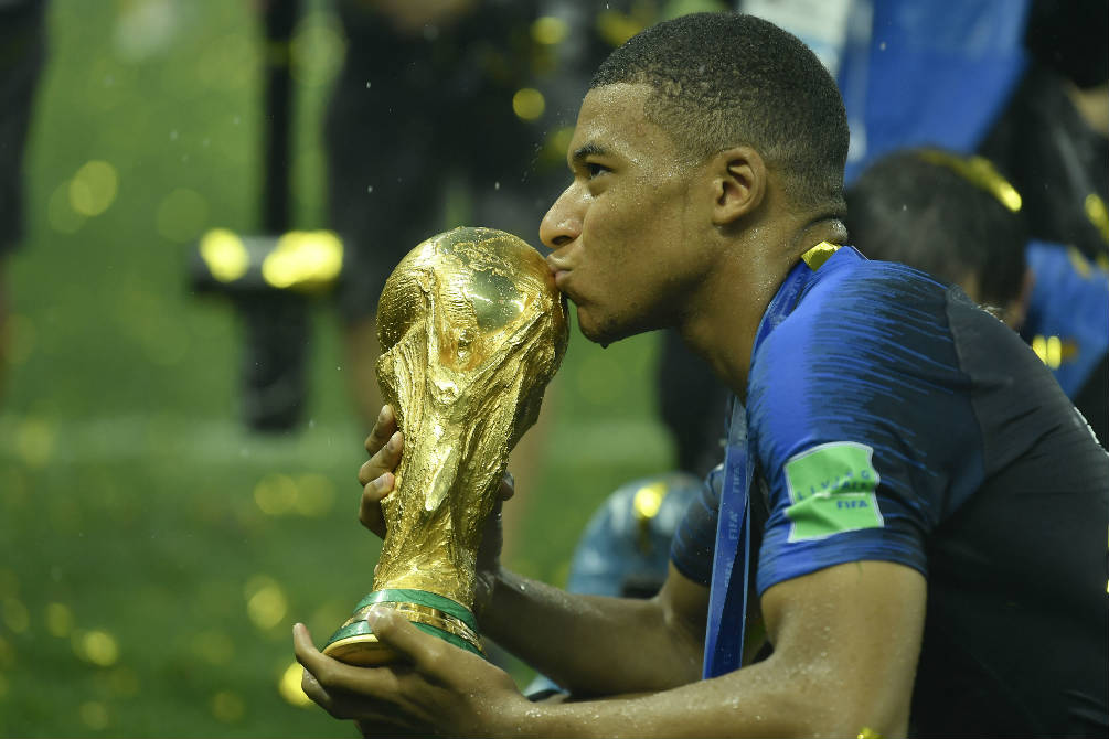Kylian Mbappé besando la Copa del Mundo