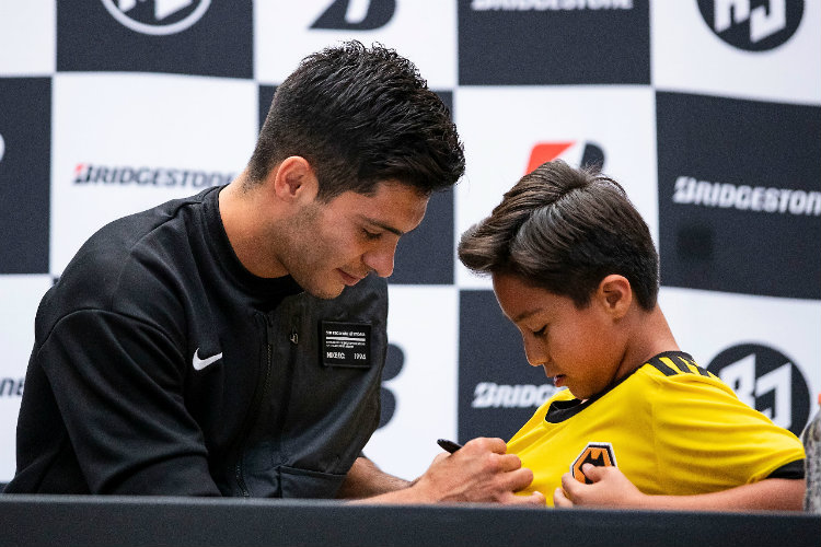 Raúl Jiménez firma el jersey de un pequeño fan 