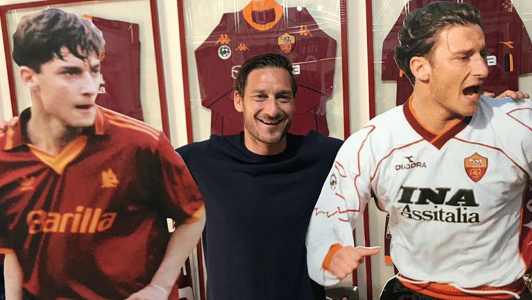 Totti posa junto a dos figuras suyas
