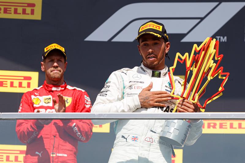 Hamilton con su trofeo ante la mirada seria de Vettel 