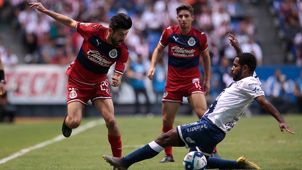 Oribe Peralta trata de esquivar a su marcador en el partido ante Puebla