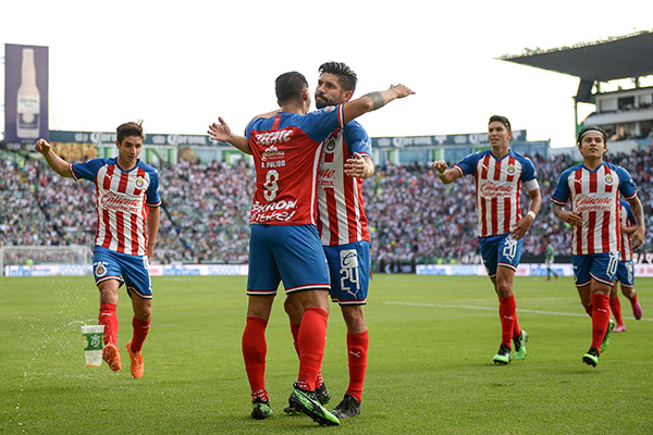 Alan Pulido festeja con Oribe un gol contra León 