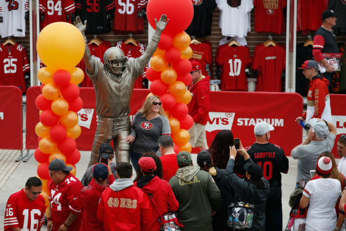 Fans posando con la estatua de Joe Montana