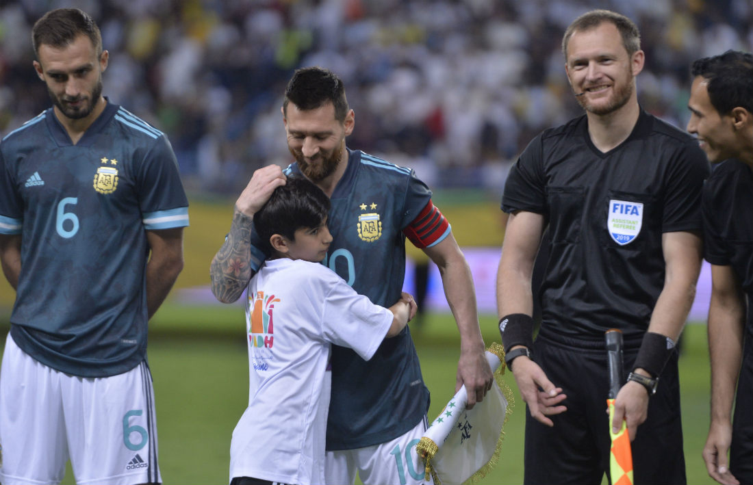 Lionel Messi abrazando a un niño previo al partido entre Argentina y Brasil