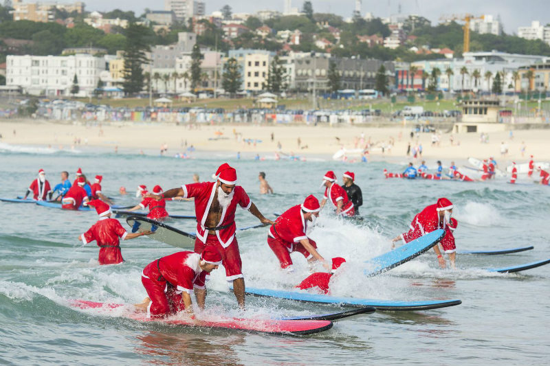 Santas surfeando en playas de Estados Unidos