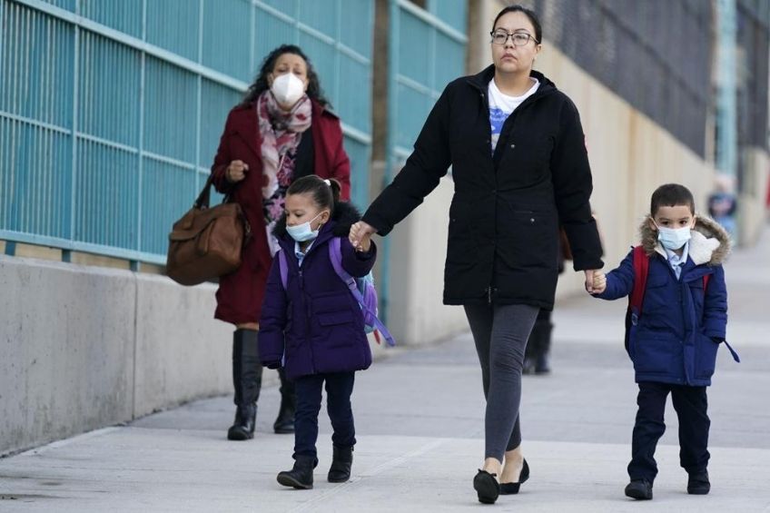 Mujer llevando a sus hijos a una escuela de Nueva York