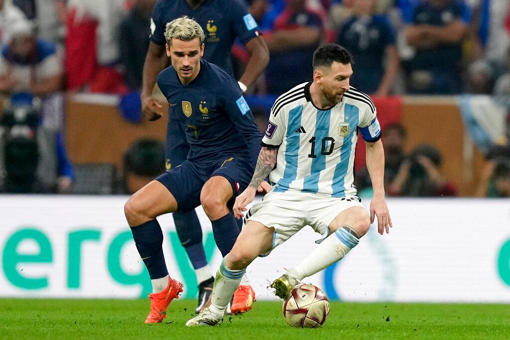 Griezmann disputa un balón con Lionel Messi