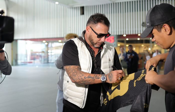 Antonio Mohamed firmando una playera de los Pumas