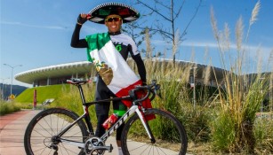 Irving Pérez posa junto con su bicicleta a las afueras del Estadio Chivas