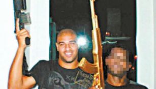 Adriano posa con un arma de fuego en una foto