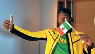 Usain Bolt posa con una bandera de México