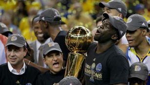 Draymond Green carga el trofeo de Campeones de la NBA