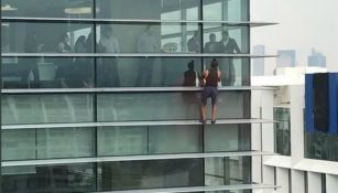 Personas observar a un sujeto escalando un edificio en Polanco