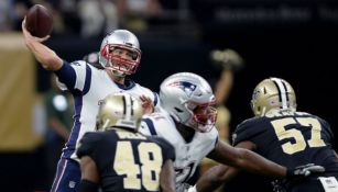 Tom Brady intenta lanzar un pase en el juego frente Nueva Orleans