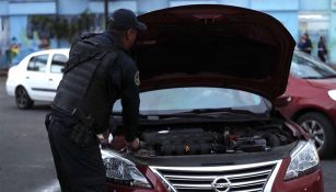 Policía revisa un auto en el dispositivo de seguridad