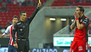 Fernando Hernández Gómez amonesta a un jugador de Xolos