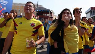 Aficionados colombianos reaccionan durante el partido contra Japón