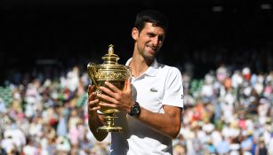 Novak Djokovic posa con el título de Wimbledon