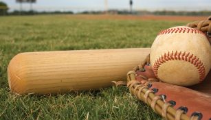 Bat, pelota y guante de beisbol en un campo