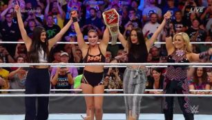 Ronda Rousey y las hermanas Bella levantando el cinturón