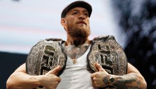 Conoi McGregor posa con sus dos campeonatos de la UFC
