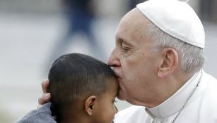 Papa Francisco le da un beso en la frente a un niño 