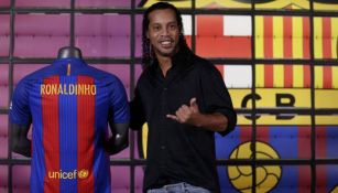 Ronaldinho posa junto a una playera del Barcelona 
