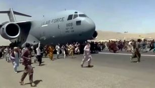 Personas corriendo junto a un avión de la Fuerza Aérea de Estados Unidos
