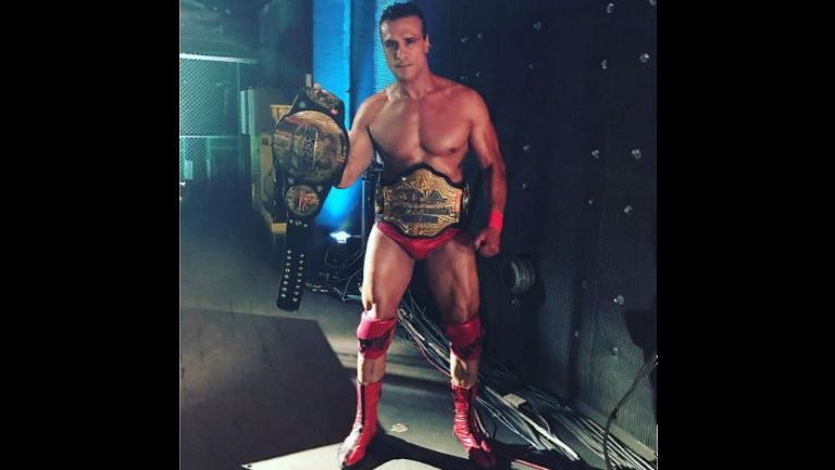 Alberto El Patrón posa con los títulos de Impact Wrestling y GFW
