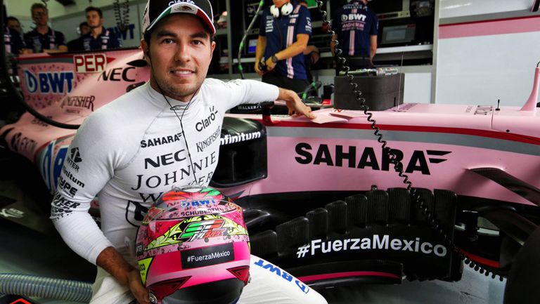 Checo luce su casco junto a su monoplaza de Force India 