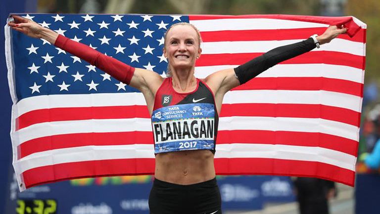 Shalane Flanagan festeja con la bandera de Estados Unidos