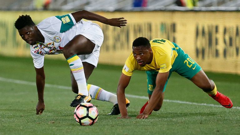 Jugadores de Sudáfrica y Senegal luchan por el balón