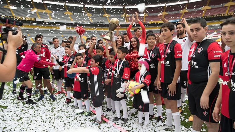 Niños posan con el trofeo en el Estadio Jalisco