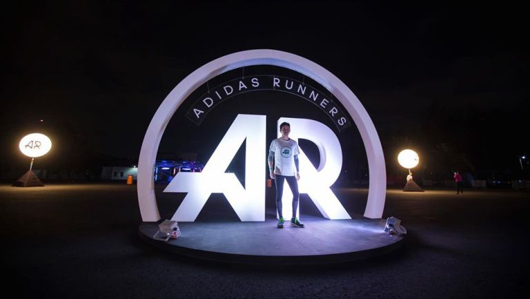 Un corredor posa frente al logo de Adidas