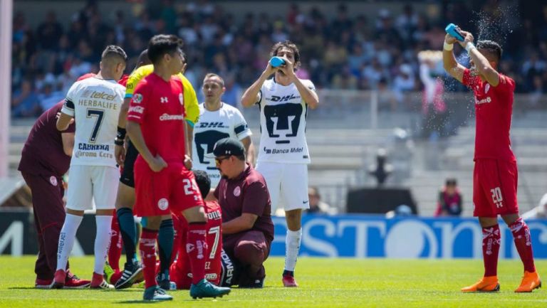 Jugadores de Pumas y Toluca hidratándose en la cancha de CU 