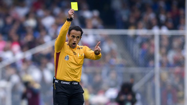 Isaac Roja muestra la tarjeta amarilla en el Pumas vs Cruz Azul del A2018