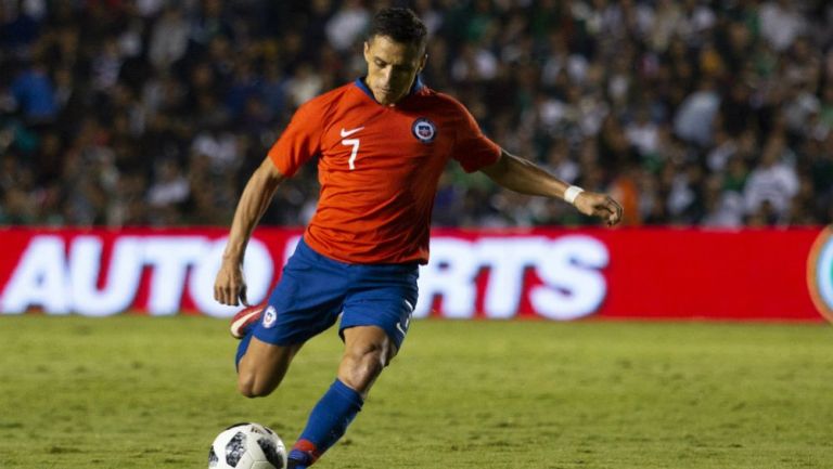 Alexis Sánchez golpea el balón en un amistoso vs México