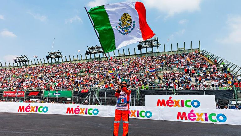 Un comisario de pista agita una bandera en el Autódromo Hermanos Rodríguez
